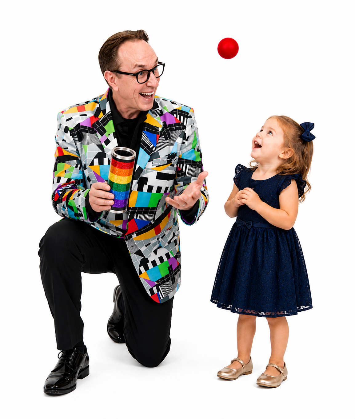 Magician kneeling with excited little girl holding a red ball at a birthday party